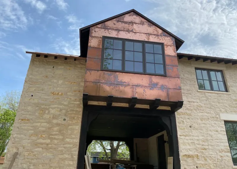 Copper metal panel facade on a stone building for Skylight Installation in Oviedo